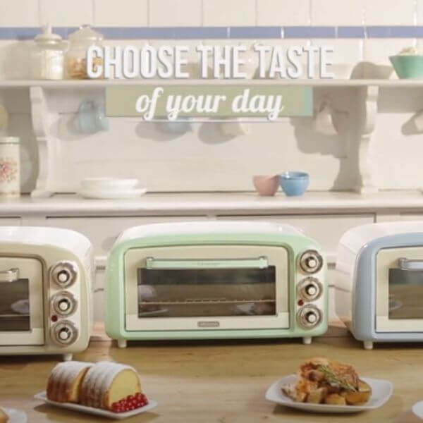 Три тостера в ретро стил върху кухненски плот с надпис "избери вкуса на деня си" над тях; чинии с храна отпред.