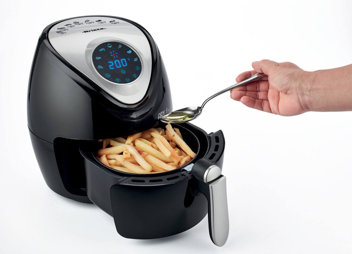 A hand is using tongs to serve french fries from a Фритюрник с горещ въздух AIRY FRYER DIGITAL.