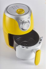 Жълт мини Фритюрник с горещ въздух AIRY FRYER MINI, 2 л с извадена кошница за готвене, поставен на бял фон.