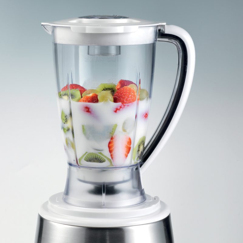 Кухненски робот ROBOMIX METAL блендер, пълен с мляко и асорти от плодове, включително ягоди, киви и банани, разположени на сив фон.