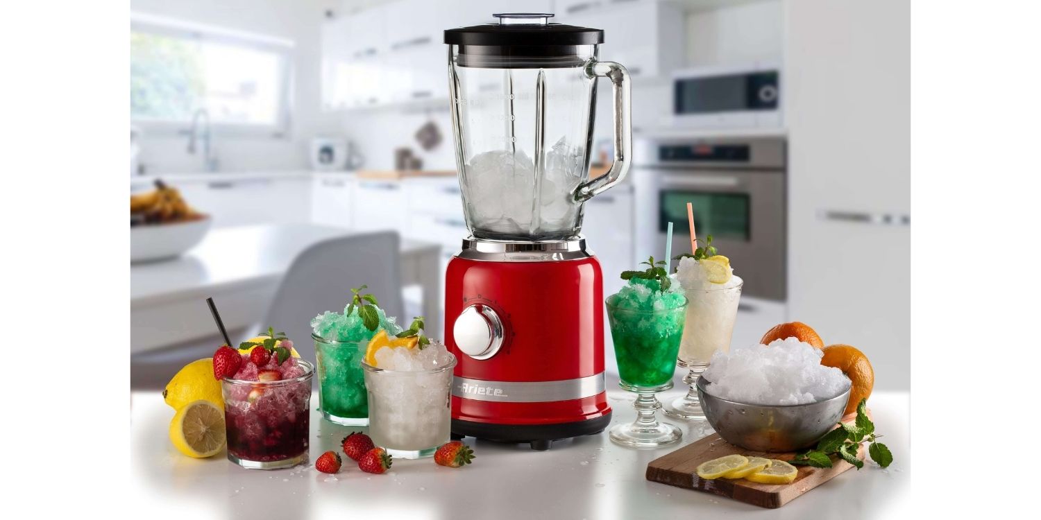 Плот Ninja Blender, пълен с натрошен лед, е заобиколен от различни ледени напитки и плодове в модерна кухня.
