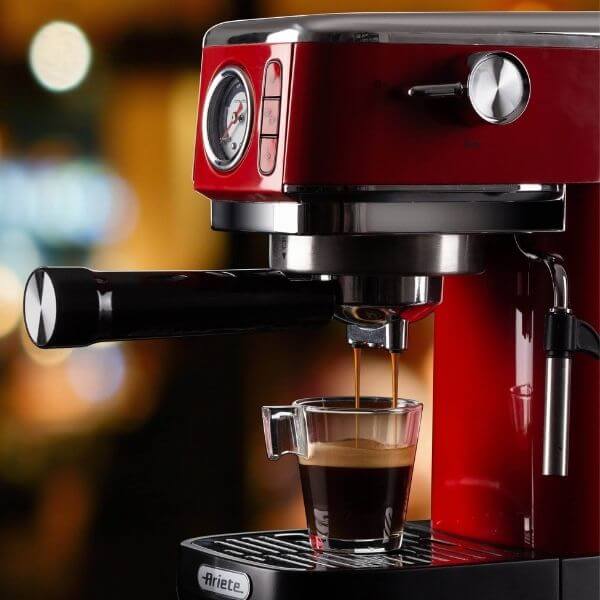 Червена Кафемашина ESPRESSO SLIM MODERNA, която налива кафе в прозрачна стъклена чаша.