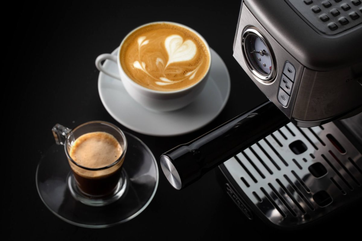 Кафемашина ESPRESSO METAL SLIM машина с чаша за кафе, пълна с лате, изобразяваща лате изкуство до друга чаша, съдържаща еспресо, поставена върху тъмна повърхност.