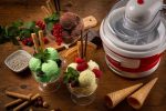 Машина за сладолед PARTY TIME седи на маса до купа със сладолед, създавайки атмосфера на PARTY TIME.