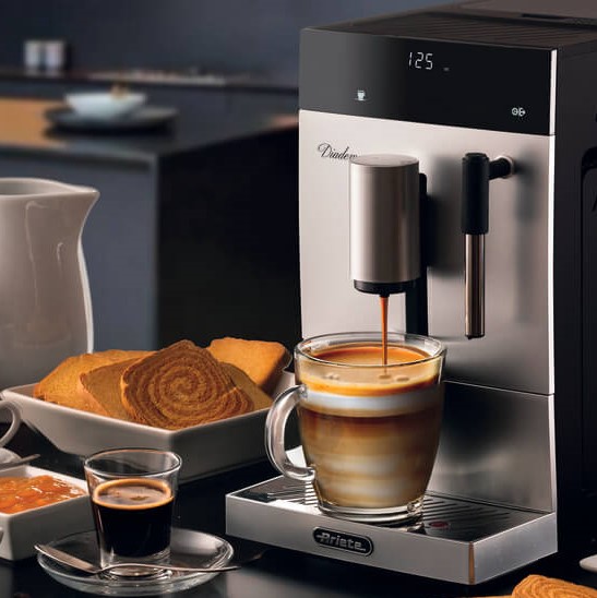 Кафеавтомат Diadema Automatica стои на маса до чаша кафе.
