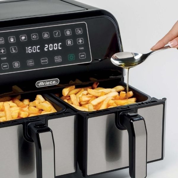 The Фритюрник с горещ въздух AIR FRYER DUAL 8л. умело приготвя пържени картофи със своите цифрови контроли. Една ръка грациозно налива олио върху пържените картофи с помощта на лъжица, подобрявайки всяка вкусна хапка.