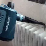 Парен пистолет VAPORÌ JET почиства бял радиатор, изпарения излизат от дюзата.