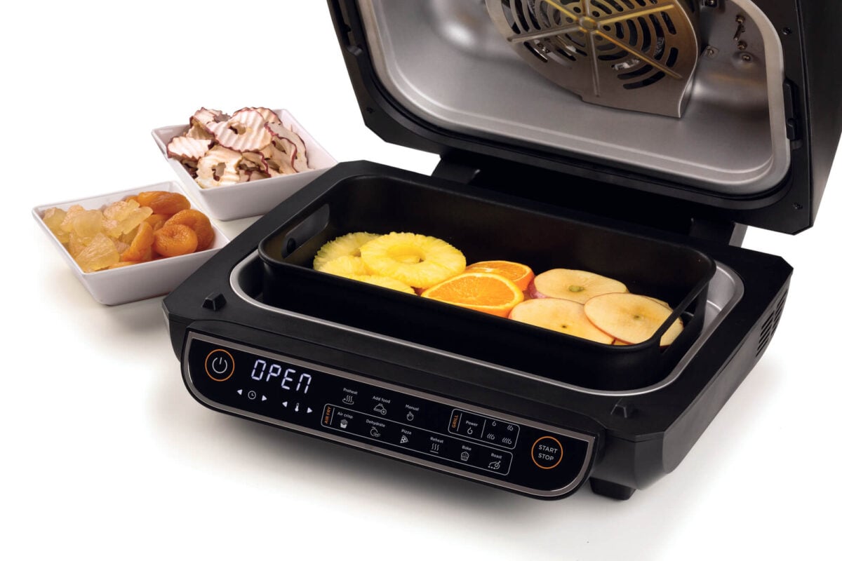 Open the Фурна с горещ въздух и грил Vintage AIR FRYER 16л. с подноси с плодове и купи със сушени закуски.