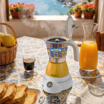 Електрическа кафемашина „Moka Vintage Positano“ върху слънчева теракотова маса, до тост и сок.
