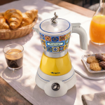 Електрическа кафемашина „Moka Vintage Positano“ стои до кафето и сладкишите, блестяща на слънчевата светлина.