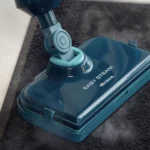 Парочистачка Easy Steam почиства тъмен килим, отделяйки видима пара върху повърхността.