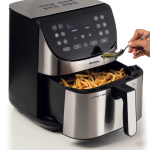 Някой добавя масло към картофите във фритюрника с горещ въздух „Airy Fryer Metal 7 Л“ с цифрово управление и стоманена кошница.