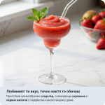 До машината за сладолед 6в1 Ariete MySlush & IceCream стои чаша с ягодов слаш, а на заден план се виждат горски плодове.