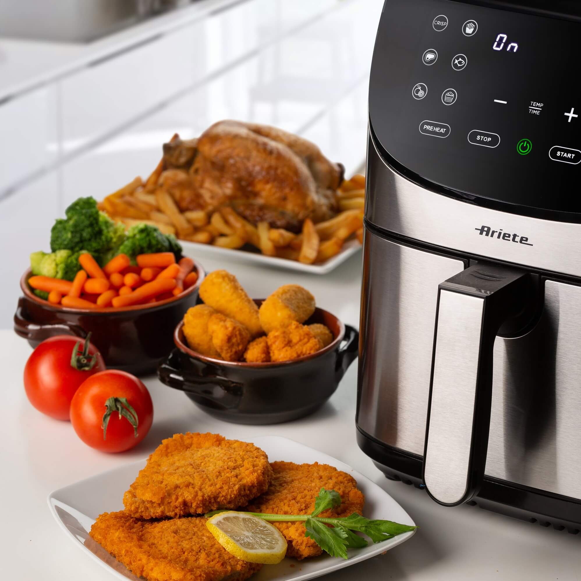 Фритюрник Airy Fryer Metal 7 л на кухненския плот с кюфтета, зеленчуци, пилешко и пържени картофи.