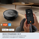 Човек управлява черната робот-прахосмукачка X-Clean 3in1 с Wi-Fi чрез мобилно приложение, докато седи на дивана. Изображението подчертава съвместимостта ѝ с Wi-Fi, дистанционно и гласово управление чрез Tuya, Google Assistant и Alexa. На заден план върху кухненския плот е поставена елегантна машина за сладолед с компресор.